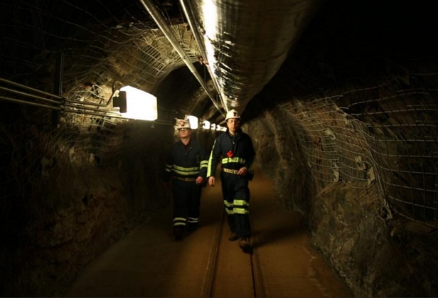 Výzkumníci procházející starým důlním tunelem
